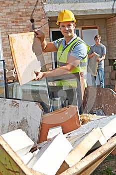 Builder Putting Waste Into Rubbish Skip