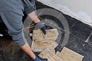 Builder removing damaged floor tiles