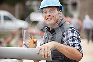 builder sawing pipe at construction site