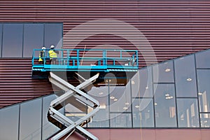 Builder on a Scissor Lift Platform at a construction site photo