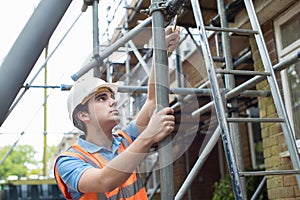 Builder On Site Putting Up Scaffolding