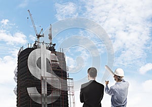 Builder and skyscraper with dollar