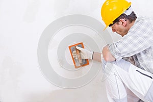 Builder smoothing new plaster on an interior wall photo