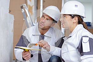builder with spatula talking to female colleague