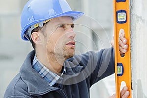 Builder with spirit level on construction site