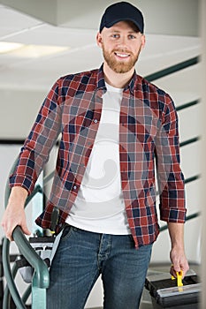 builder standing on staircase smiling at camera