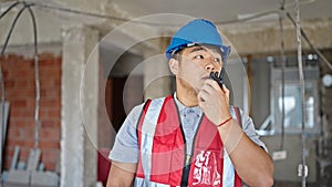 builder talking on walkie talkie at construction site