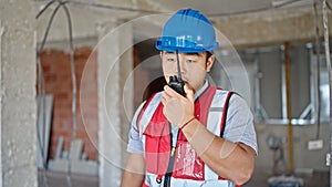 builder talking on walkie talkie at construction site