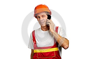 Builder talks on smartphone.