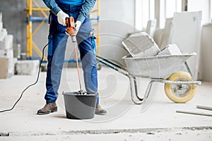 Builder mixing plaster at the construction site