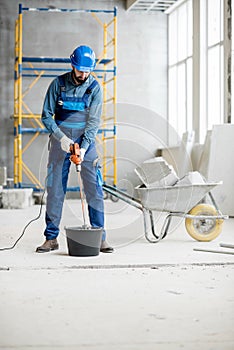 Builder mixing plaster at the construction site