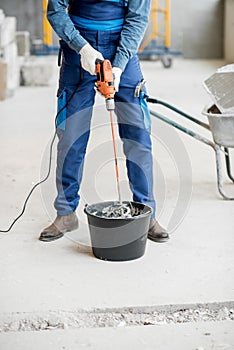 Builder mixing plaster at the construction site