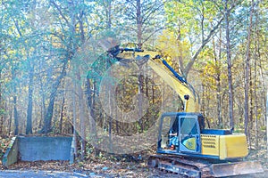 Builder uproots trees in a forest with tractor so that land can be prepared for construction