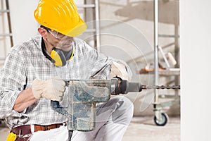Builder using a handheld power drill