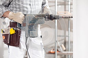 Builder using a handheld power drill