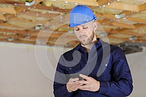 builder with van checking text messages on mobile phone