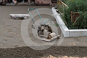 Builder with vibratory plates seals the base sand for pouring concrete