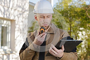 builder on walkie talkie outdoors construction photo