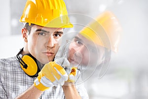 Builder reflected in glass on site