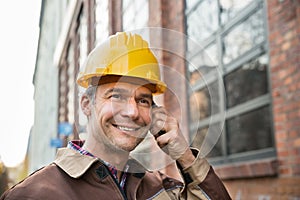 Builder wearing hardhat talking on walkie talkie