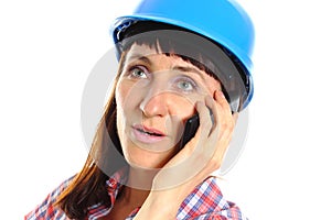 Builder woman in protective helmet talking on mobile phone