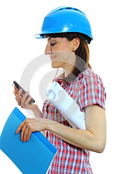 Builder woman in protective helmet using mobile phone