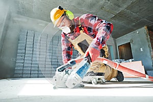 Builder at work. cutting concrete floor for cabling by diamond slitting machine