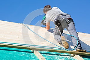 Builder at work with wooden roof construction.