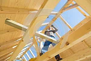 Builder at work with wooden roof construction.