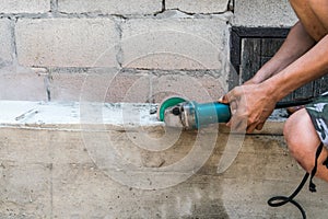 Builder worker with grinder machine cutting finishing concrete w