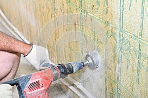 Builder worker man with hammer drill perforator