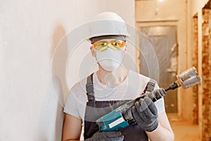 Builder worker man makes selfie photo with safety glasses and white helmet with pneumatic hammer drills