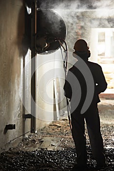 Builder worker operating demolition machine