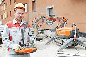 Builder worker operating demolition machine