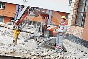 Builder worker operating demolition machine