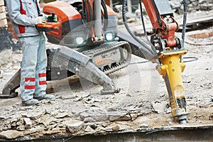 Builder worker operating demolition machine