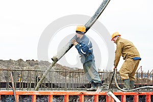 Builder worker pouring concrete into form