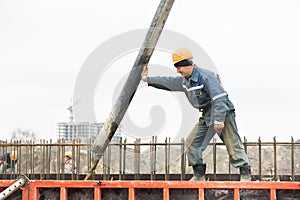 Builder worker pouring concrete into form