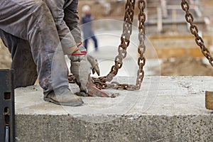 Builder worker preparing concrete profile for crane lifting