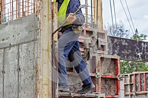 Builder worker removing formwork elements with crowbar
