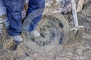 Builder worker tamping sand bedding with a feet 2