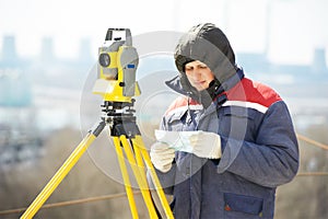 Surveyor worker with theodolite at construction site