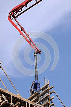 Builder worker with tube from truck mounted concrete pump