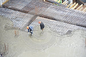 Builder workers at concrete pouring work