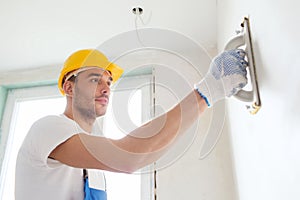 Builder working with grinding tool indoors