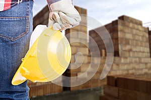 Builder with yellow helmet and working gloves