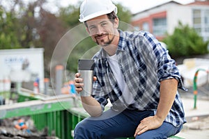 Builderon break drinking coffee from insulated cup