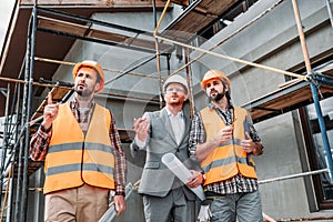 builders and architect looking away in front of