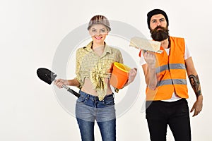Builders with brick, shovel and bucket, couple in love makes repair white background. Repairman with girlfriend, copy