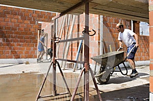 Builders carrying wheelbarrows photo